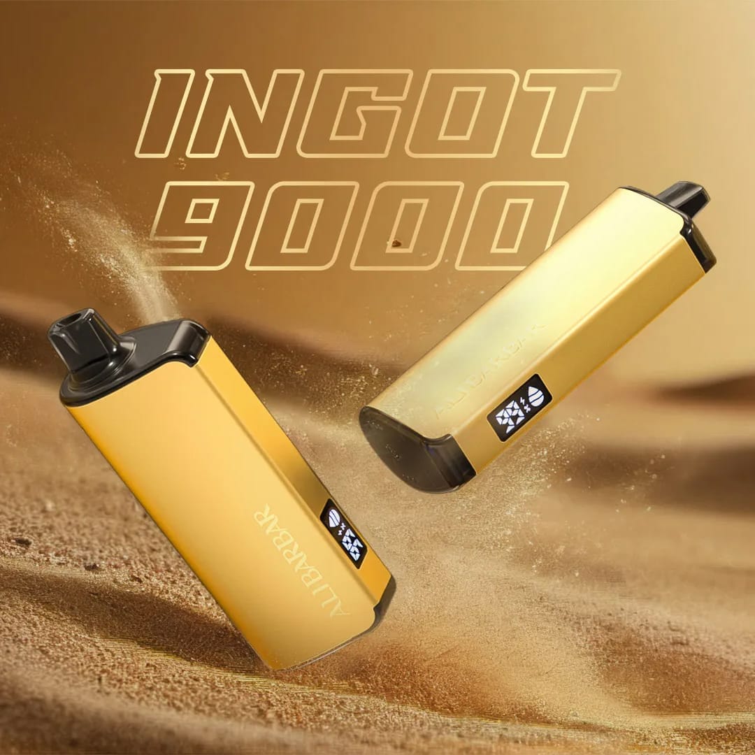A sleek, polished gold Alibarbar Ingot vape device elegantly placed on a marble tabletop in a trendy cafe, emphasizing its luxury accessory feel and understated style.