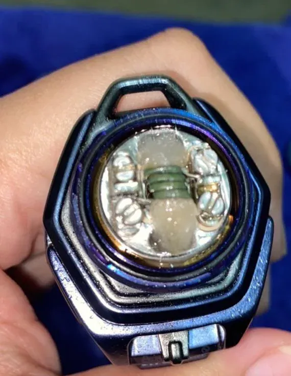 A vape device with thick, sticky e-liquid residue coating its exterior, pooling around airflow holes.