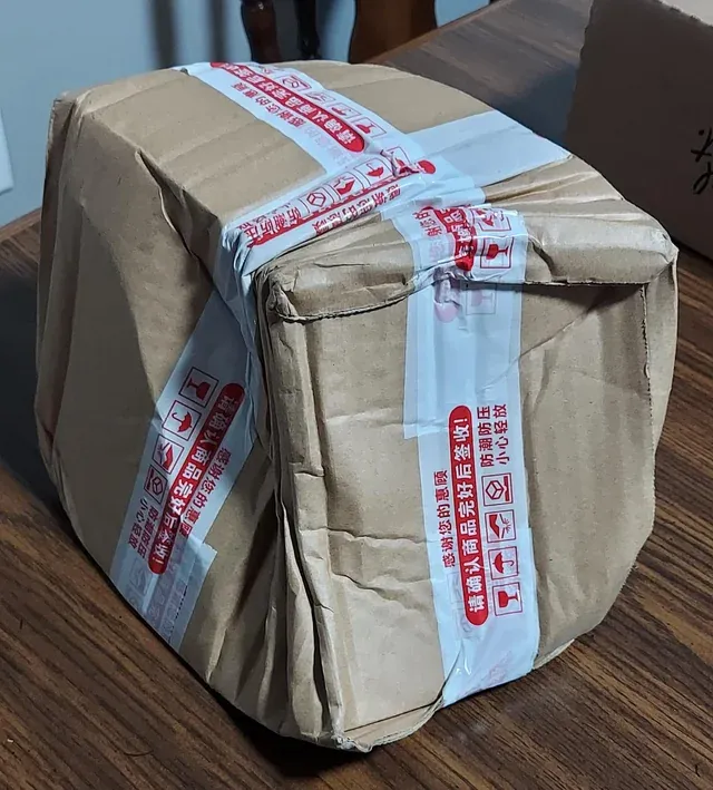 A person holding up a small, broken item, looking disappointed, symbolizing a faulty purchase from an overseas seller.