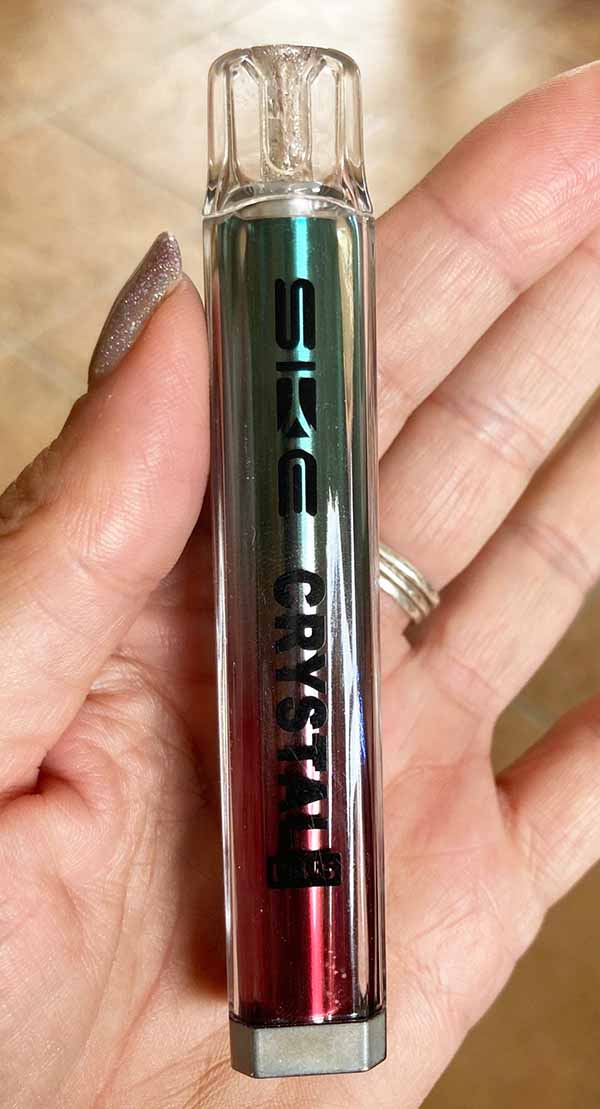 A vape device being held in an adults hand, demonstrating its real-world size and ergonomic fit for scale.